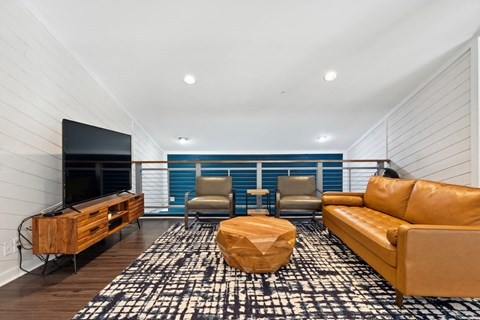 a living room with a leather couch and a television